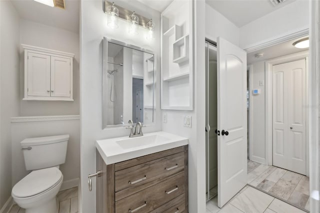 bathroom featuring baseboards, vanity, and toilet