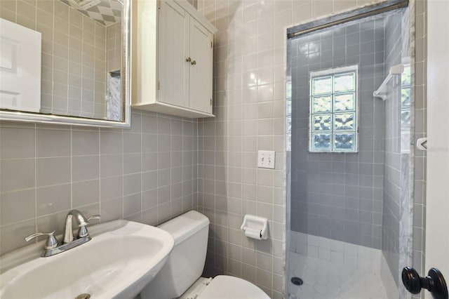 full bath featuring toilet, a sink, tile walls, a shower stall, and tasteful backsplash