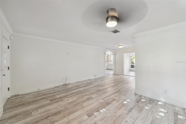 unfurnished room featuring visible vents, ornamental molding, a ceiling fan, light wood-type flooring, and baseboards