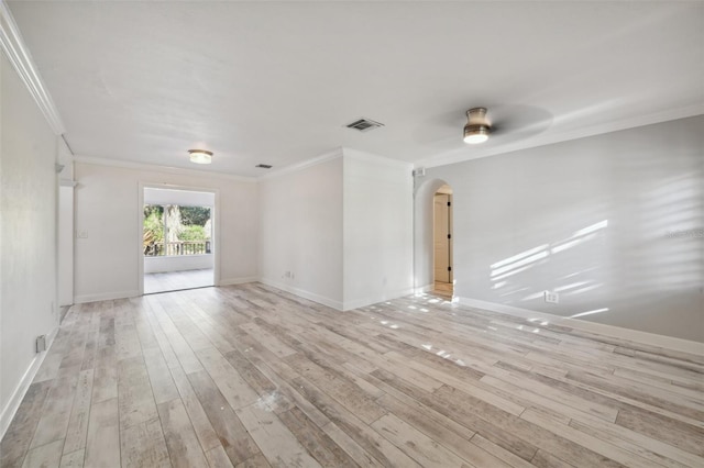 unfurnished room featuring light wood-style floors, visible vents, arched walkways, and ornamental molding