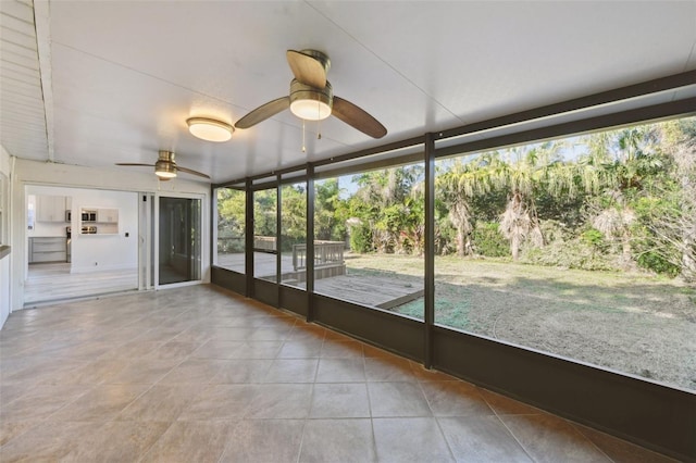 unfurnished sunroom featuring a ceiling fan