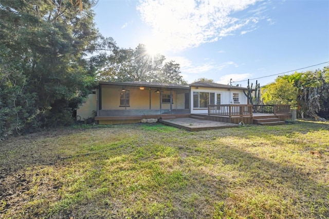 rear view of property with a lawn and a wooden deck