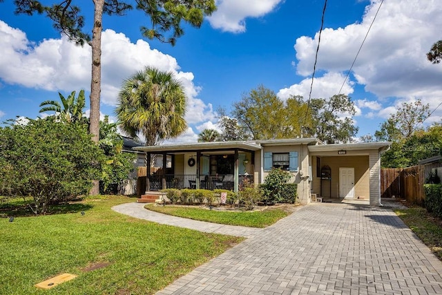 view of front of house with a porch, decorative driveway, a front yard, and fence