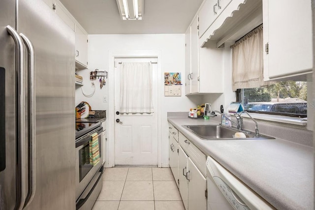 kitchen with light tile patterned floors, white cabinets, appliances with stainless steel finishes, light countertops, and a sink