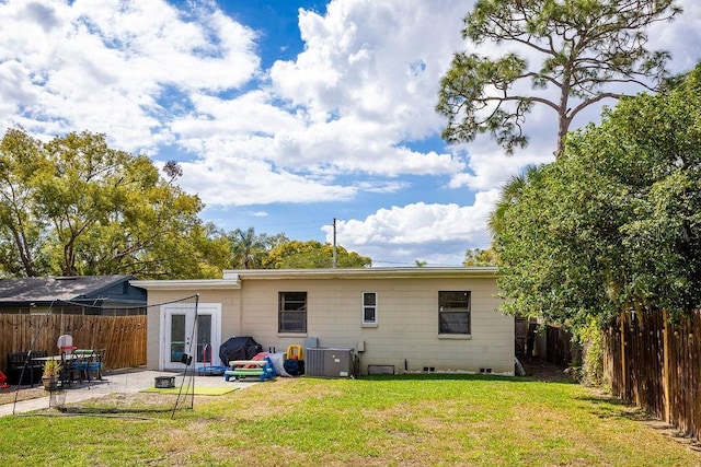 back of house featuring a patio, a fenced backyard, a yard, cooling unit, and french doors