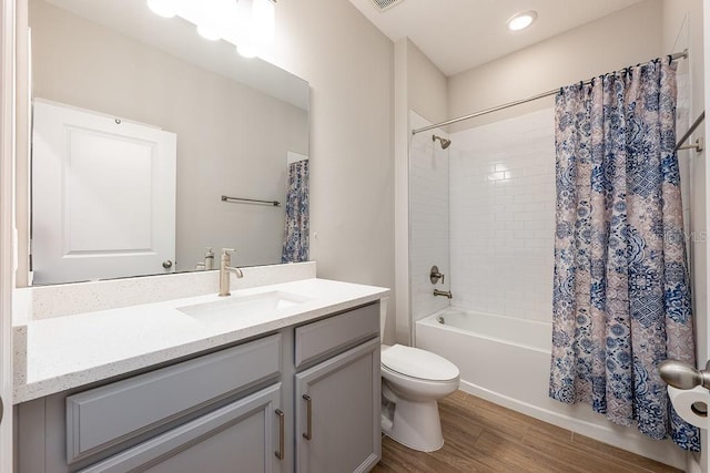 full bathroom with vanity, wood finished floors, toilet, and shower / tub combo with curtain