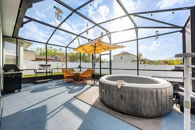 view of patio / terrace featuring glass enclosure, a fenced backyard, area for grilling, outdoor dining space, and a hot tub