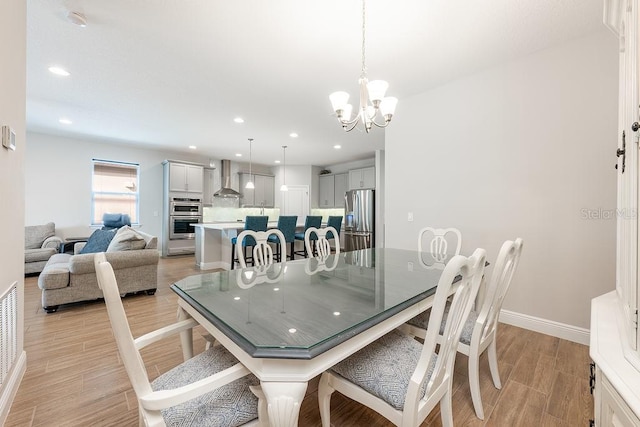 dining room with light wood finished floors, baseboards, a chandelier, and recessed lighting