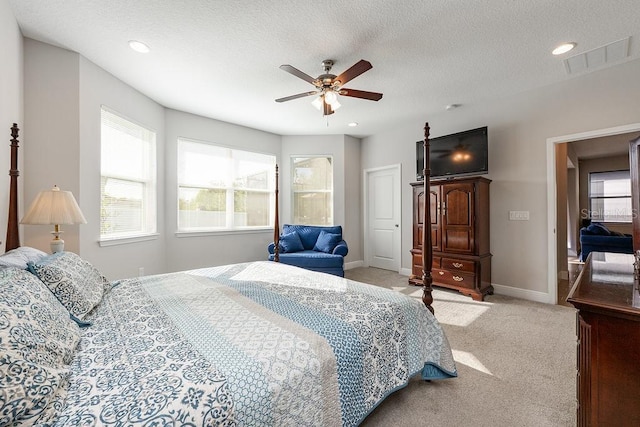 bedroom with carpet, visible vents, a textured ceiling, and multiple windows