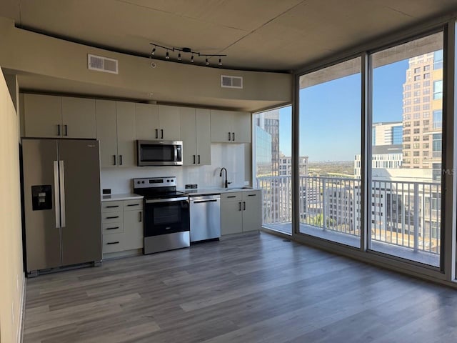 kitchen with visible vents, stainless steel appliances, wood finished floors, and light countertops