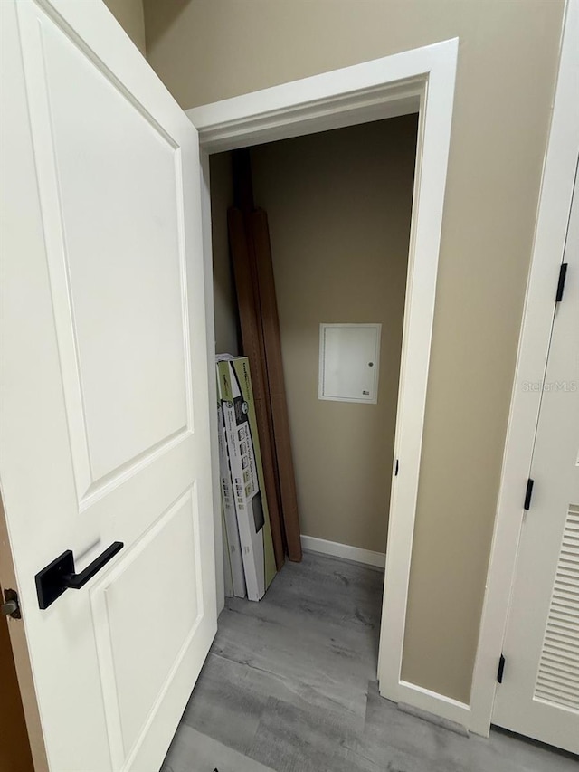 corridor featuring light wood-style floors and baseboards