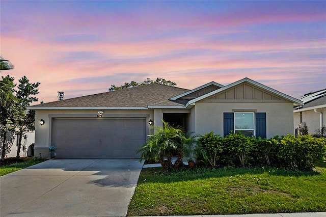 ranch-style house with a garage, stucco siding, concrete driveway, and a yard