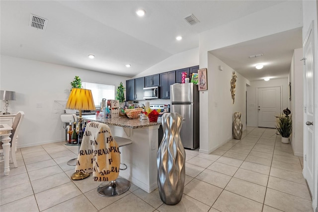 kitchen featuring light tile patterned floors, visible vents, dark stone counters, lofted ceiling, and stainless steel appliances