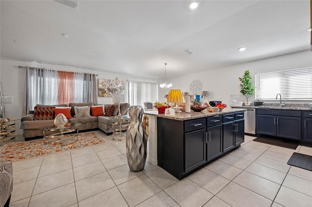 kitchen with light tile patterned floors, light stone counters, open floor plan, and a chandelier