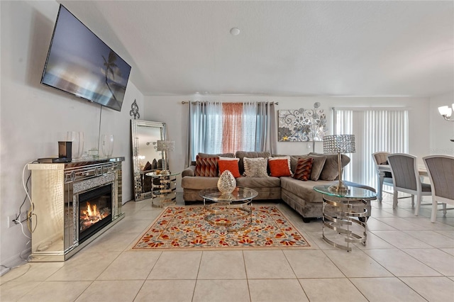 living area featuring light tile patterned floors and a glass covered fireplace