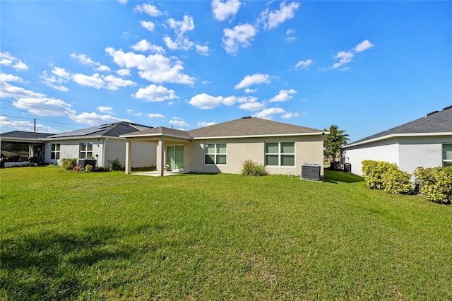 back of property featuring a lawn, cooling unit, and stucco siding