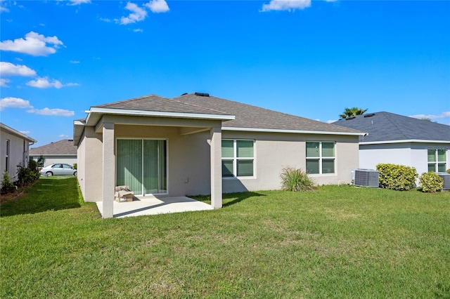 back of house featuring a patio, stucco siding, a shingled roof, a lawn, and central AC unit