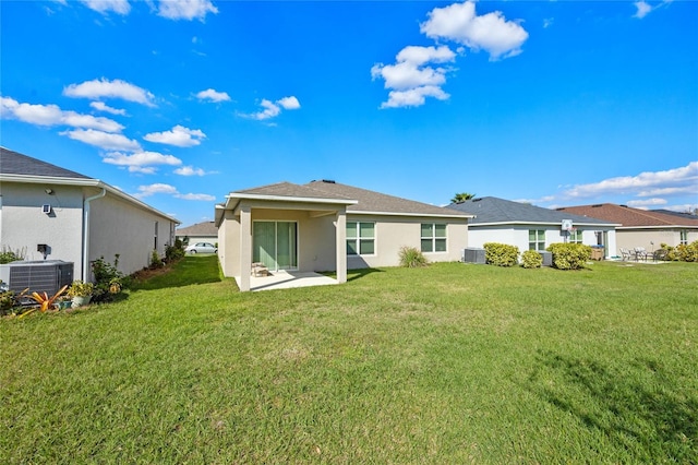 back of house with central AC, a yard, and a patio