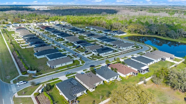 birds eye view of property with a water view, a residential view, and a view of trees