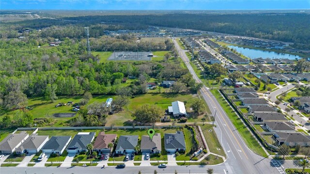 birds eye view of property with a water view, a residential view, and a wooded view