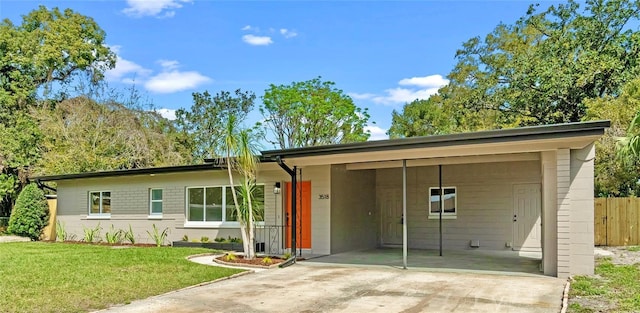 ranch-style home featuring an attached carport, fence, a front lawn, and concrete driveway