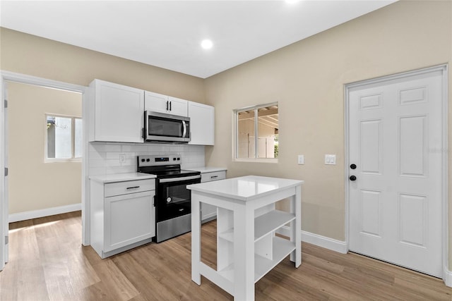 kitchen with open shelves, light countertops, decorative backsplash, appliances with stainless steel finishes, and white cabinets