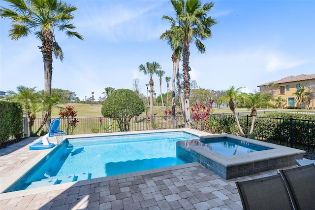 view of pool with a fenced backyard and a pool with connected hot tub