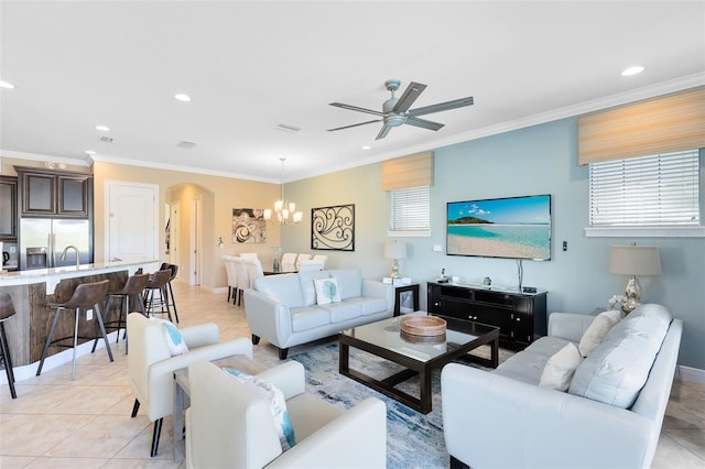 living area featuring arched walkways, light tile patterned floors, recessed lighting, and crown molding