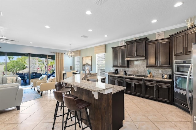 kitchen with light tile patterned flooring, open floor plan, stainless steel appliances, and a sink