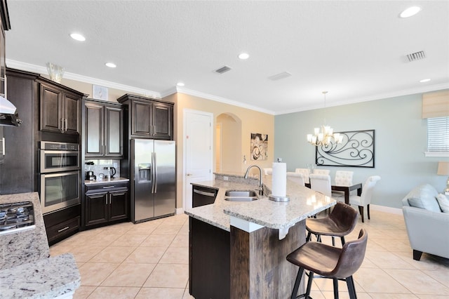 kitchen featuring a sink, stainless steel appliances, a breakfast bar, and light tile patterned floors