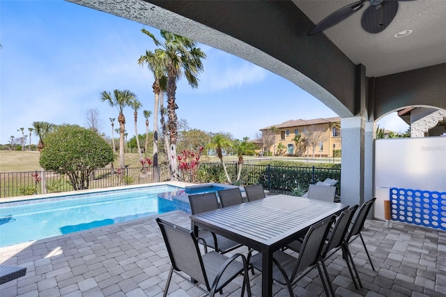 view of swimming pool with a pool with connected hot tub, fence private yard, a patio, and a ceiling fan