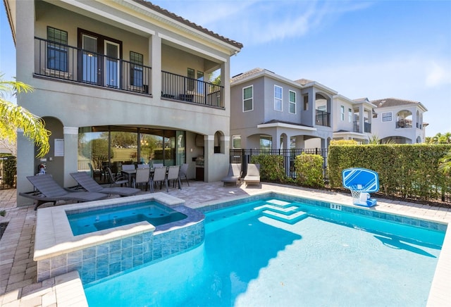 view of swimming pool with outdoor dining area, a patio area, fence, and a pool with connected hot tub