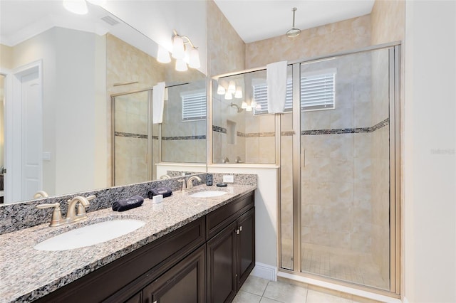 bathroom with tile patterned flooring, a shower stall, double vanity, and a sink