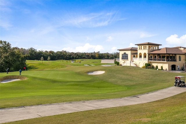 view of home's community with a lawn and view of golf course