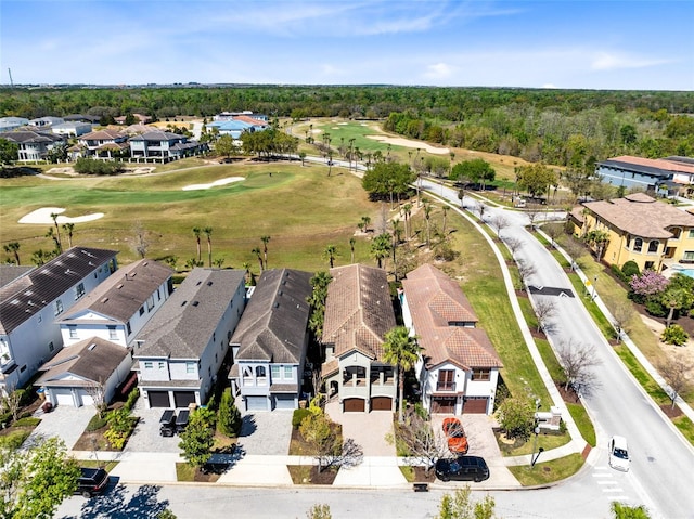 drone / aerial view featuring view of golf course and a residential view