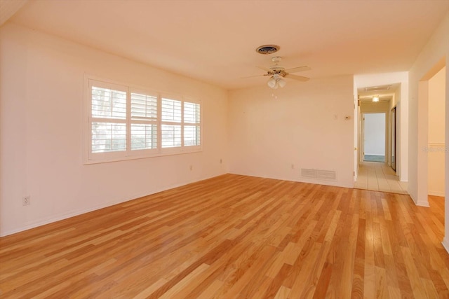 unfurnished room featuring a ceiling fan, visible vents, and light wood-style flooring