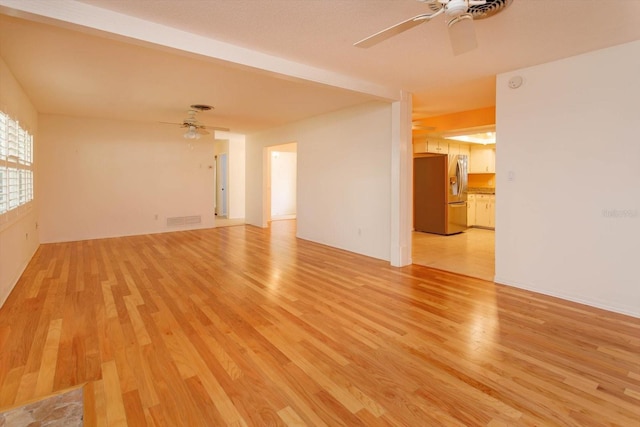 empty room featuring light wood-style floors, ceiling fan, and visible vents