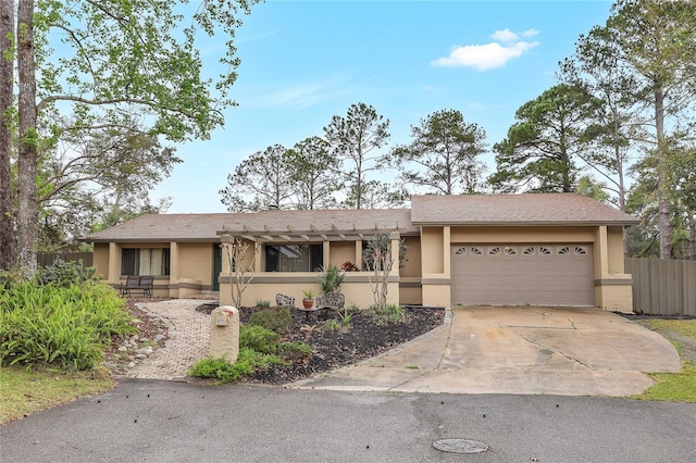 single story home with stucco siding, an attached garage, fence, a pergola, and driveway