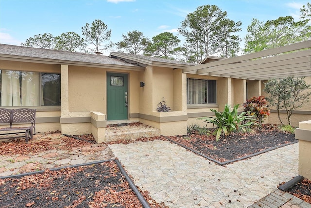 view of front of property featuring a shingled roof and stucco siding