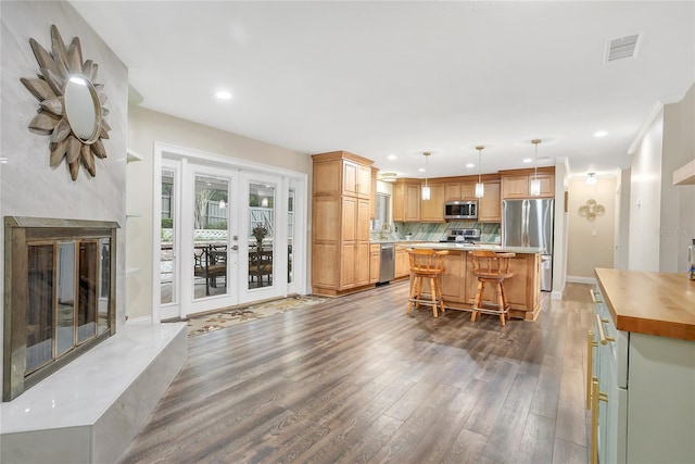 kitchen featuring french doors, visible vents, decorative backsplash, appliances with stainless steel finishes, and dark wood-type flooring