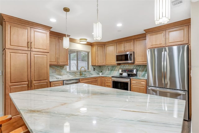 kitchen with stainless steel appliances, visible vents, a sink, and light stone countertops