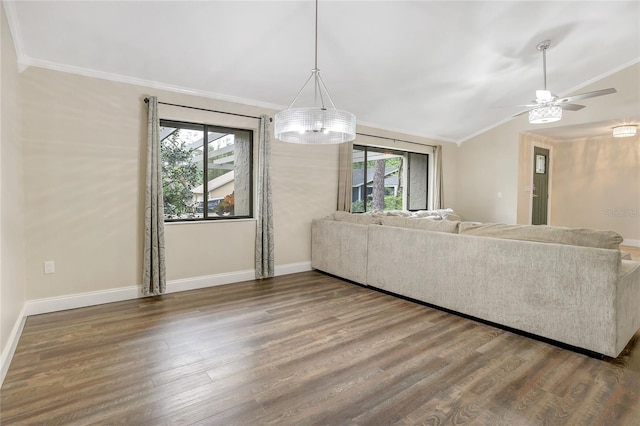 living area featuring lofted ceiling, crown molding, baseboards, and wood finished floors