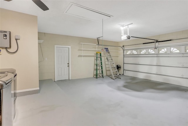 garage with washer and clothes dryer, concrete block wall, and a garage door opener