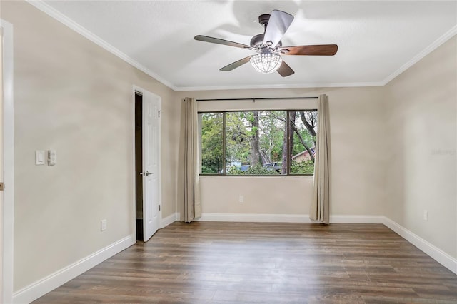 empty room featuring crown molding, wood finished floors, and baseboards