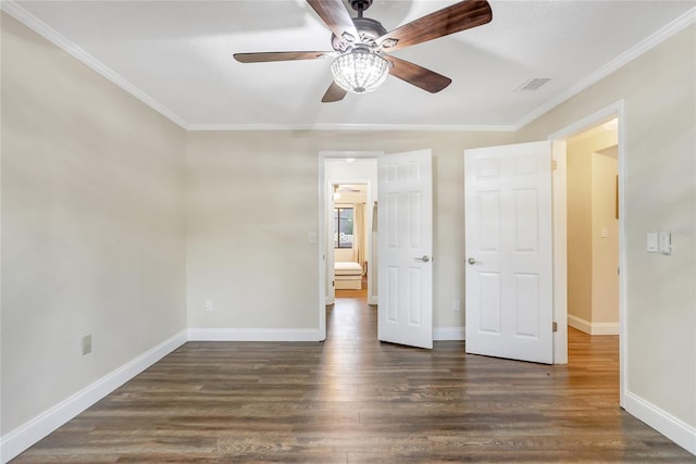 unfurnished bedroom with dark wood-style floors, crown molding, visible vents, and baseboards