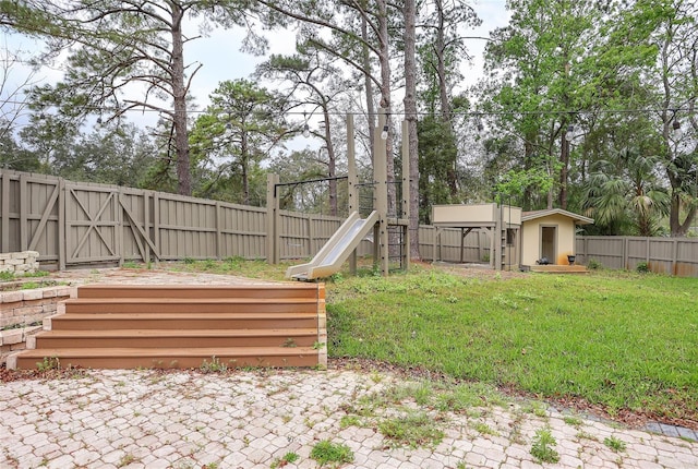 view of yard featuring a fenced backyard, an outdoor structure, a storage shed, and a patio