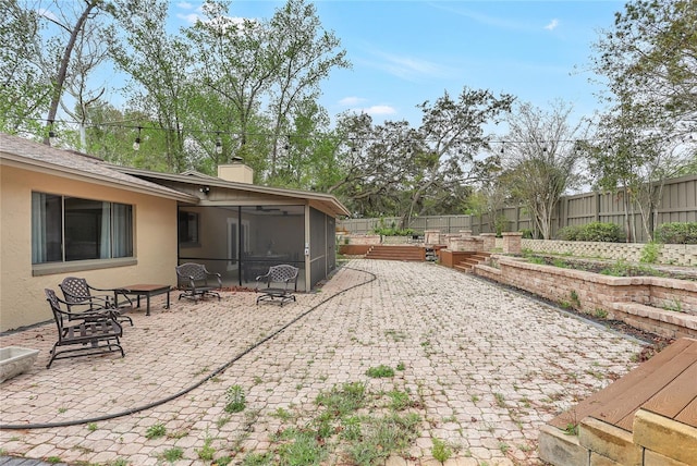 view of yard with a sunroom, a fenced backyard, and a patio