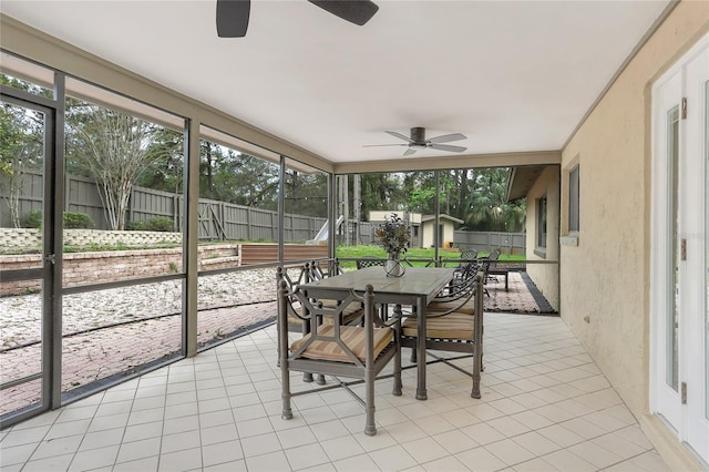 sunroom / solarium featuring a healthy amount of sunlight and a ceiling fan