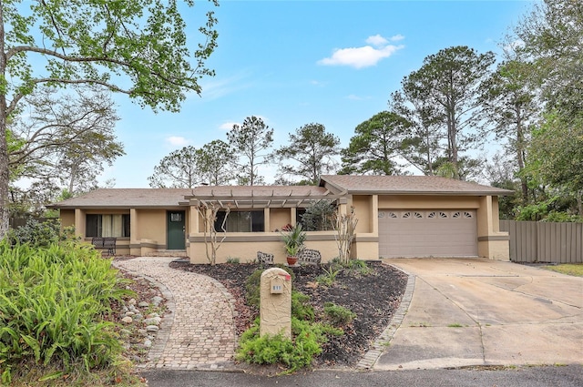 ranch-style house featuring driveway, fence, an attached garage, and stucco siding