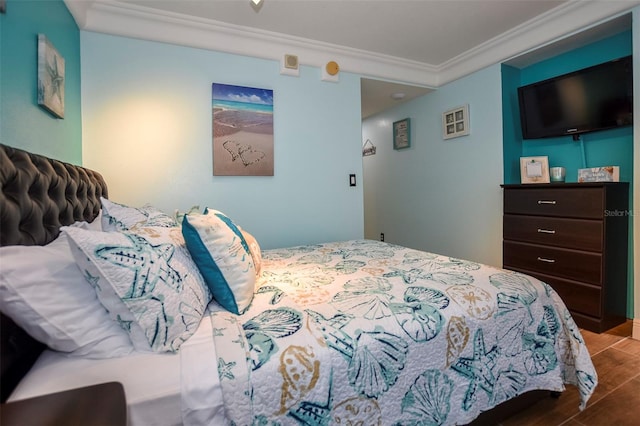 bedroom featuring ornamental molding and wood finished floors